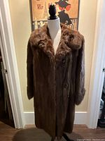 Full front view of the coat on dress form showing double-breasted front and shawl collar