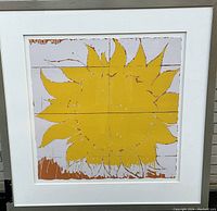 Framed artwork full view showing yellow sun motif on white mat within silver metal frame