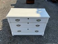 Front view of dresser showing three drawers and brass handles