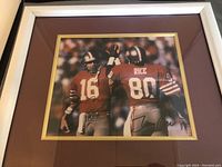 Framed color photograph of Joe Montana and Jerry Rice in 49ers uniforms, signed by both players.