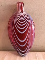 Front angle of cranberry glass flask showing white swirl ribbon pattern.