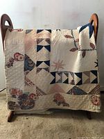 Full front view of quilt draped over rack showing overall pattern and color scheme