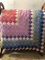 Full view draped over rack showing gradient diagonal diamond design and scalloped border