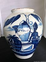 Side view of Delft jar showing painted imagery of 'St Vinsen' jar, tropical plants and seated figure.