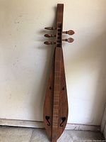 Full view of the teardrop five-string lap dulcimer showing its shape and wooden finish