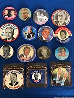 Photo showing 15 political buttons spread out on a blue background showcasing various US political figures and campaigns.