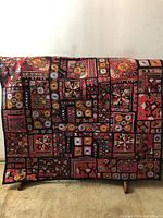 Full view of the tapestry draped over a stand, showing overall pattern and colors