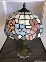 Full view of the Tiffany style lamp showing stained glass floral shade and metal base.