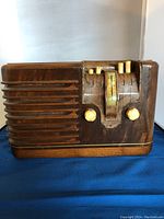 Front view of the vintage Clarion Art Deco radio with wood casing and tuning knobs.