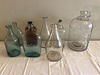 Full group of eight vintage bottles showing variety of colors and shapes
