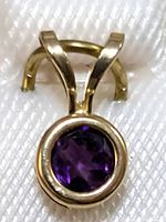 Close-up of the pendant showing the amethyst stone set in yellow gold bezel setting.