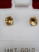 Close up photo of both round citrine stud earrings in white display card marked 14KT GOLD.