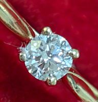 Close-up front view of round brilliant lab diamond set in four-prong 10K yellow gold setting