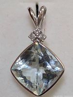 Front-facing view of cushion-cut aquamarine pendant in white gold setting