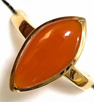 Close-up photo of marquise-shaped orange carnelian gemstone set in silver ring band