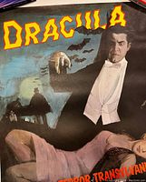 Close-up image of the Dracula poster showing the upper half of the vampire figure, yellow 'Dracula' text, and bats flying in the background.
