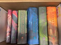Photo of all seven Harry Potter hardcover books in original dust jackets, showing the spines and colors clearly.