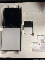 Iota Abode security camera and small sensors in molded packaging tray.