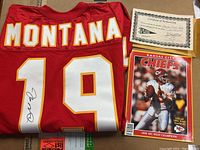 Folded red mesh #19 Kansas City Chiefs jersey signed on numeral, Certificate of Authenticity, and team yearbook displayed