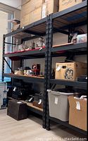 Photo showing full view of shelving unit loaded with various boxes and items showing size and structure.