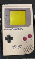 Front view of Nintendo Game Boy handheld console showing the screen, D-pad, A and B buttons, select and start buttons.