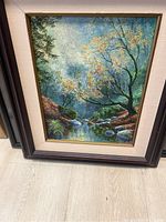 Overall view of framed and matted landscape painting showing wood frame and linen mat.
