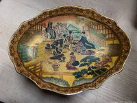 Top down view of the Satsuma style Japanese pedestal plate showing the elaborate hand-painted scene.