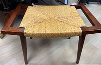 View showing the top and seat of the bench with its woven fiber pattern and wooden frame.