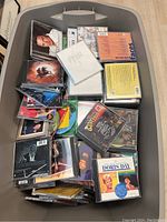 Image showing a large plastic tub filled with various CDs in jewel cases. Visible artists include Doris Day and others.