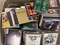 Plastic tub filled with stacked CDs showing some labeled and uncluttered covers.