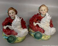 Front view of two identical Royal Doulton porcelain figurines 'Home Again', each showing the girl with the dog in her lap.