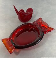 Photo showing both MCM red art glass pieces: the owl ashtray and the smaller bird figurine