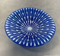 Top view of cobalt blue art glass bowl showing white radial elongated dot pattern.