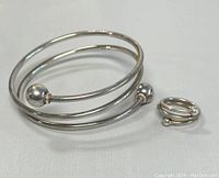 Coil cuff bangle and ring set on white surface, showing overall appearance and scale.