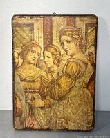 Front view of vintage wooden wall hanging plaque showing detailed painting of three women in Renaissance style attire with warm colors.