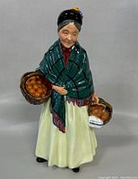 Front view of the ceramic figurine "The Orange Lady" showing detailed colors and baskets with oranges.