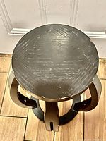 Top view showing scratched and chipped paint on the circular metal surface of the plant stand.