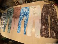 Photo of five pairs of girls leggings laid out on a table in various colors and patterns.