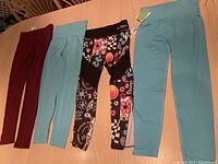 Four pairs of girls leggings laid out on table showing colors and patterns.