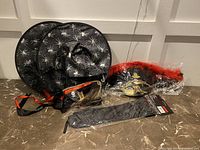 Overview of Halloween accessories showing witch hat, pirate hat, masquerade mask, and packaged black fabric item