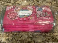 Stack of folded LOL Surprise reusable treat bags in pink with mermaid and star graphics, sealed in plastic packaging.