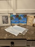 Photo showing five different photo albums with various cover designs and two packs of clear plastic photo sleeves on a marble surface.