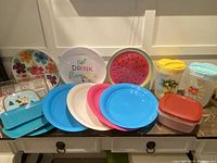 Photo of new plastic trays, juice jugs, and containers on a wooden surface