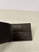 Open bifold wallet showing left side card slots and embossed Timberland logo in lower right corner.