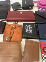 Grouped assorted wallets including leather and synthetic in various colors and styles