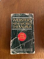 Front cover of Webster's New World Thesaurus by Charlton Laird, visibly worn and creased