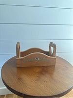 Front and side view of the solid wood caddy box with subtle hand painted floral decoration on a round wooden table against a neutral background.