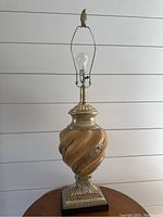 Table lamp base with swirled gold design, bulb socket, no lampshade included.
