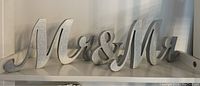 Photo of a wooden Mr & Mr sign painted silver placed on a flat surface
