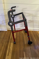 Side view of Roami 4-in-1 walker showing red and gray frame, ergonomic handles, and wheels for mobility and stair assistance.